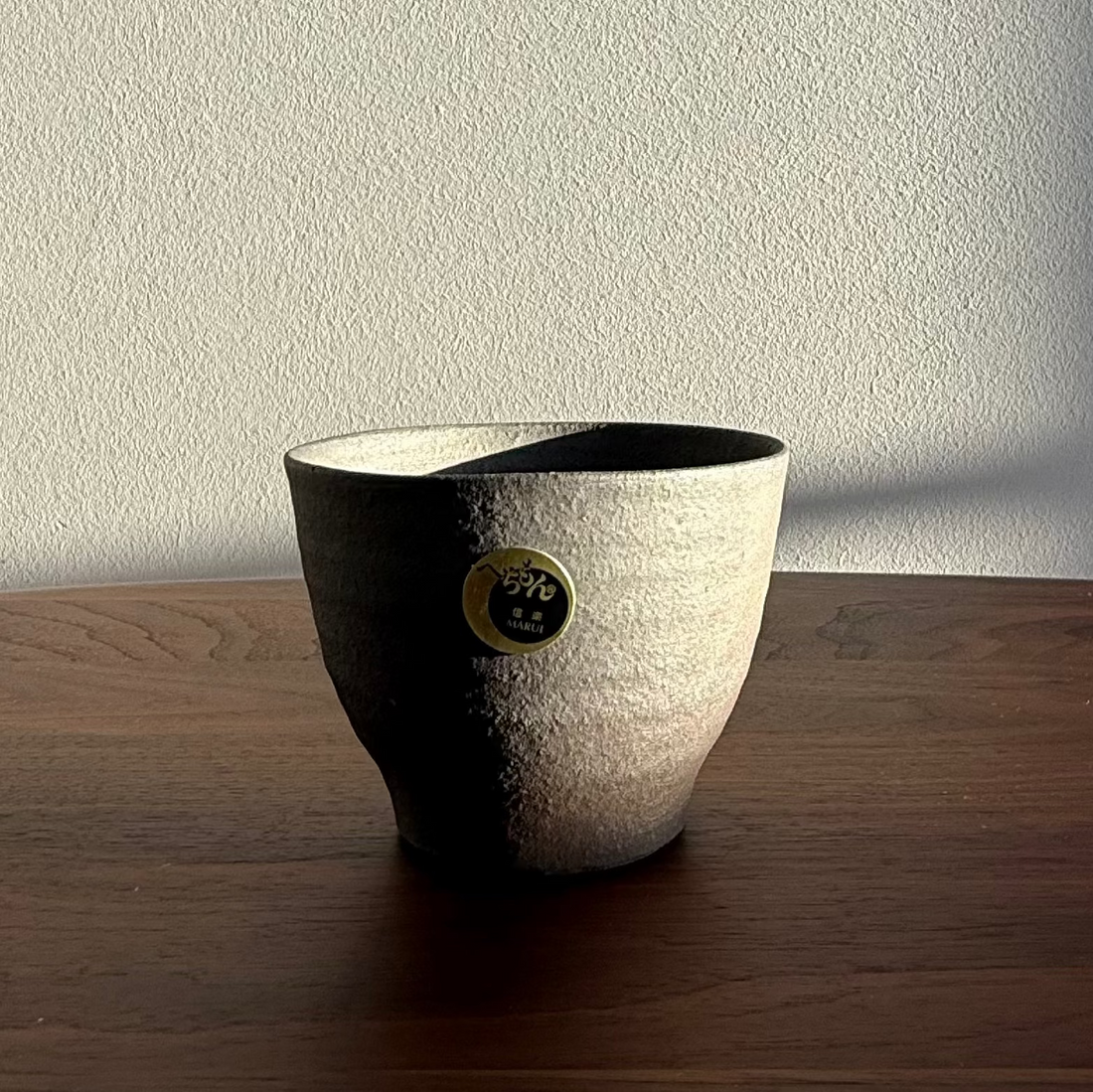Ceramic pot with a textured finish on a wooden surface
