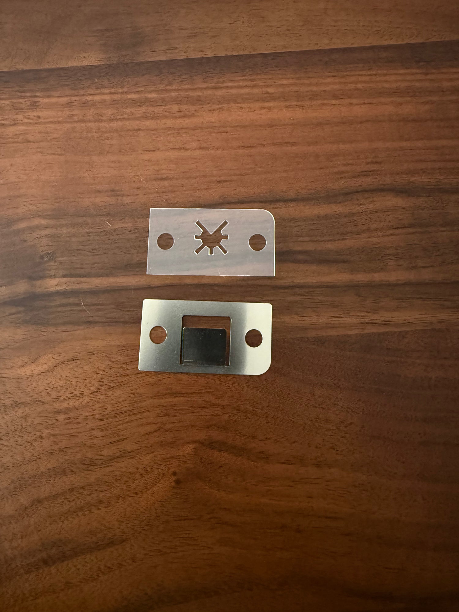 Metal and plastic pieces of the declumper for the DF54 Coffee Grinder on wooden surface 